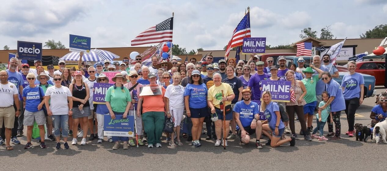 Photo of a large group of volunteers gathered and posing for a photo just before the parade start